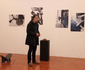 pessoa na sala e quadros atras